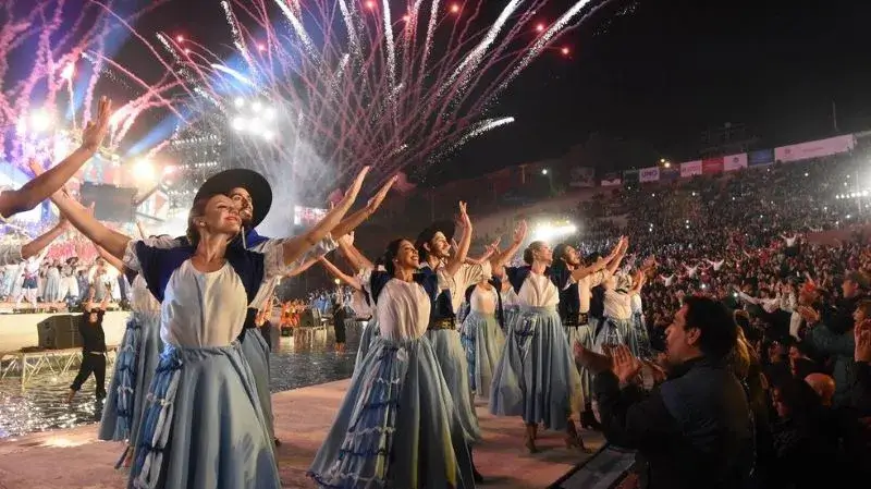 Personas vestidas de gauchos y paisanas bailando en la Fiesta de la Vendimia