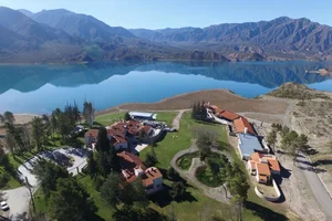 Vista aérea de Luján de Cuyo, con el lago y las montañas de fondo.